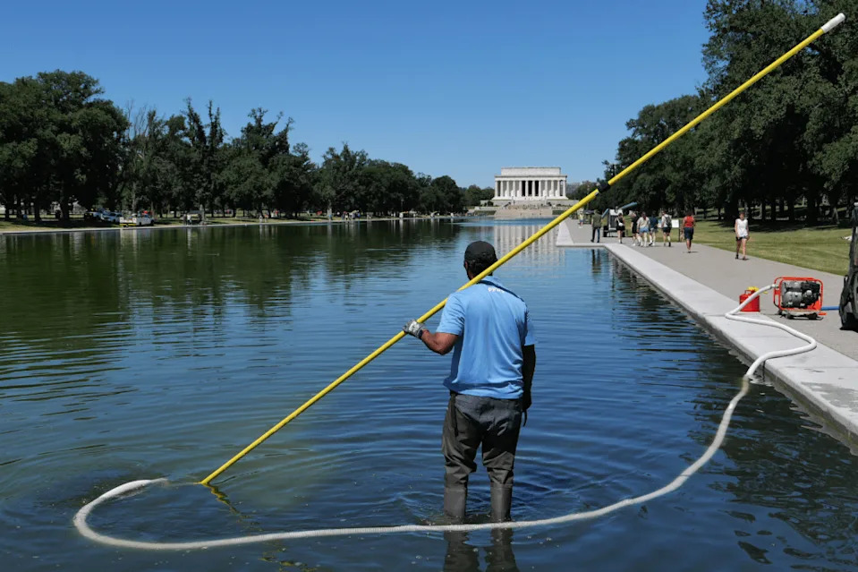 Workers Pour Hydrogen Peroxide Into Lincoln Memorial Reflecting Pool After Rapid Algae Bloom Turns Water Green